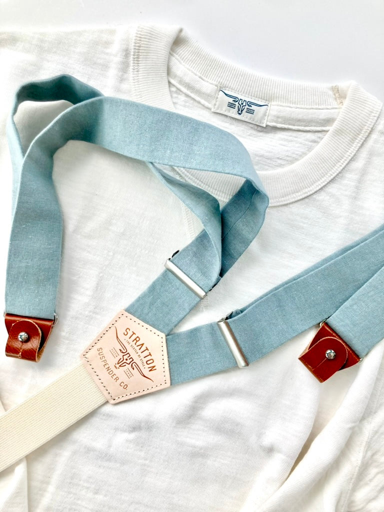 Vintage 1940s Heavyweight T-Shirt in White by Stratton Suspender Co, styled with Dusty Blue Linen Suspenders. Showcasing heritage American workwear with premium handmade suspenders featuring leather button attachments and a classic Y-back design.