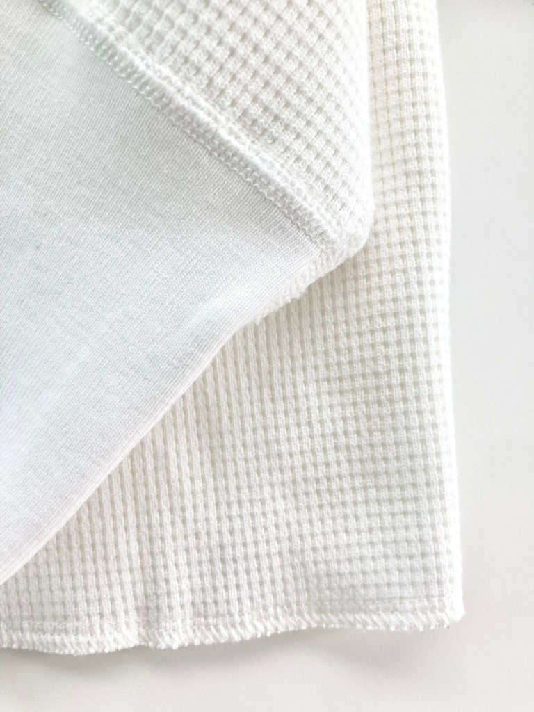 Close-up of the heavyweight white waffle knit thermal shirt’s cuff and textured fabric. Features reinforced ribbed cuffs and classic waffle-knit construction for durability and warmth. Ethically made in the USA by Stratton Suspender Co.