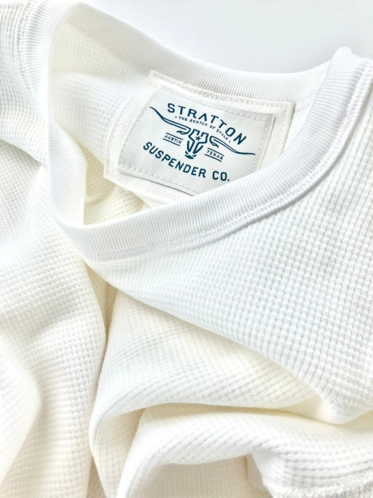 Close-up of a vintage-inspired white waffle knit thermal shirt, showcasing its textured fabric, ribbed collar, and the Stratton Suspender Co. label. Ethically made in the USA, this heavyweight thermal is designed for durability, warmth, and timeless American workwear style.