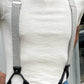 Close-up of vintage charcoal beige linen suspenders with black leather button-on attachments and silver adjusters, styled with jeans and a cream crewneck—ideal for groomsmen, rustic weddings, and modern vintage menswear.