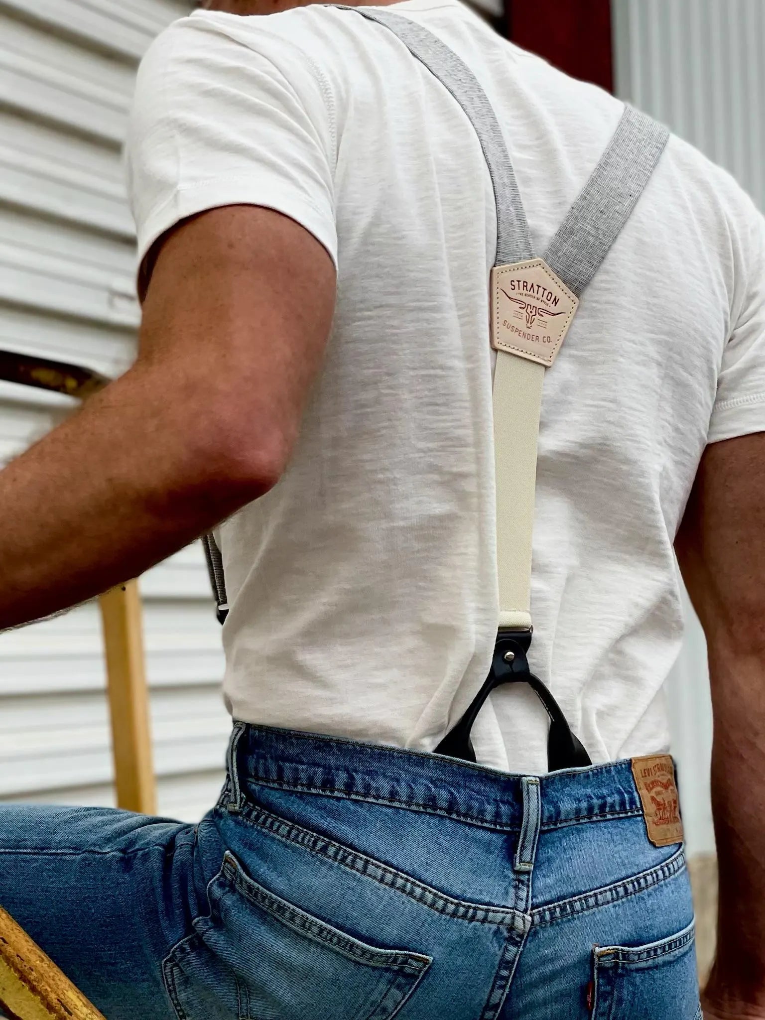 Back detail of Stratton Suspender Co. vintage charcoal linen suspenders with black leather button-on attachments, paired with a white tee and Levi’s jeans—handmade groomsmen accessories from Texas.