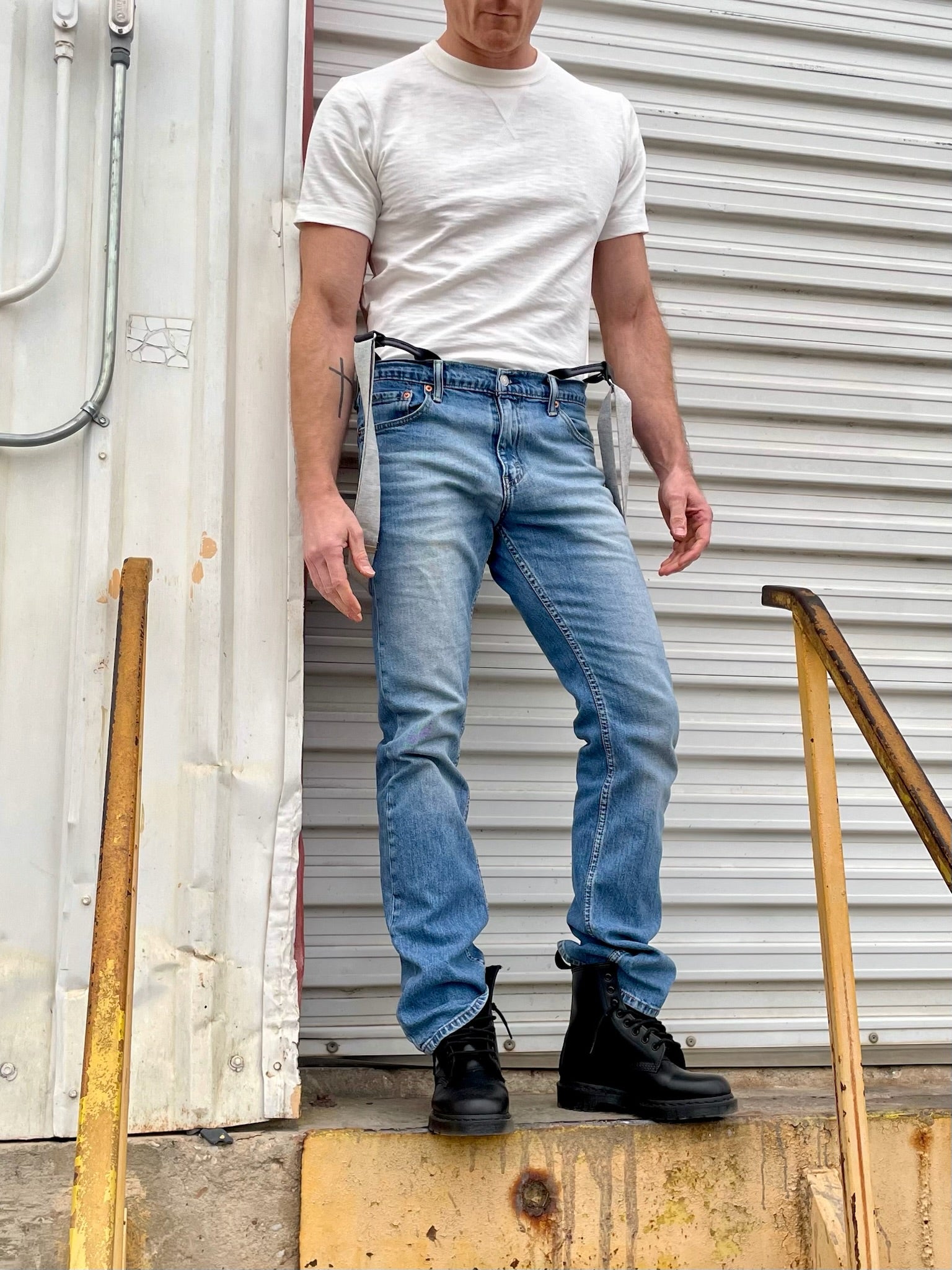 Stratton Suspender Co. fitted vintage woven t-shirt paired with classic woven button-on suspenders, Levi’s jeans, and black Dr. Martens boots. A timeless heritage menswear look inspired by Austin, Texas street style. Ethically crafted for casual and formal wear.