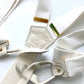 Close-up of white tuxedo button-on suspenders with gold brass hardware by Stratton Suspender Co., featuring leather button attachments and a vintage-inspired design—perfect for weddings, formal events, and classic menswear styling.