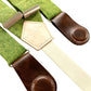 Close-up of women’s chartreuse green linen suspenders with dark brown leather magnetic clasps and cream backstrap.