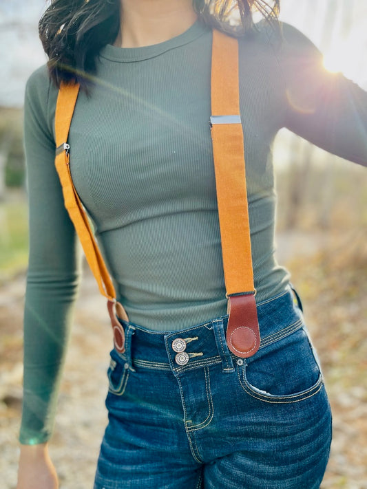 Women’s tangerine orange linen suspenders with tan magnetic clasps—boho western fall fashion accessory.