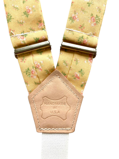 Back patch detail of yellow floral women’s suspenders with polished hardware, handmade in the USA.