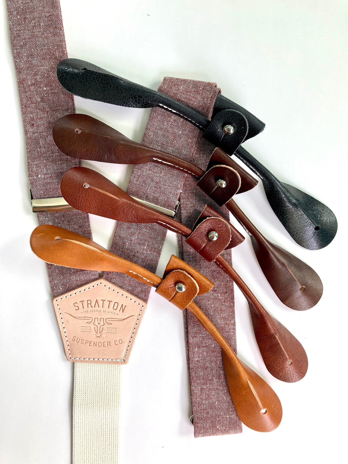 Maroon Linen Stratton Suspender Co. Set with one button on attachment in the following colors from top to bottom: Black, Chocolate (dark brown), Cognac (reddish brown), Tan (light brown)