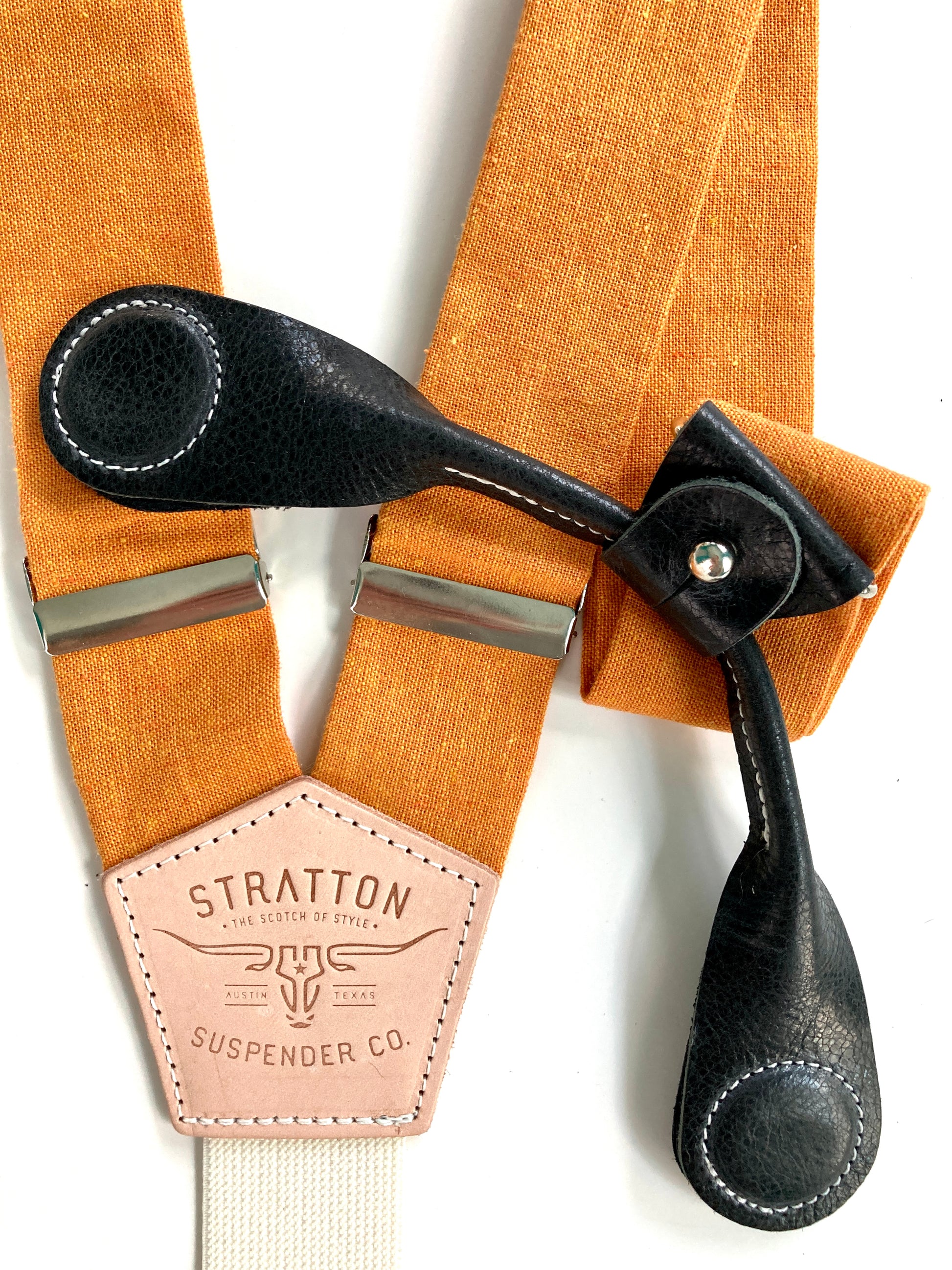 Stratton Suspender Co. features the orange linen suspenders on veg tan shoulder leather with cream colored elastic back strap for the Fall 2022 suspenders collection Magnetic Stratton Suspender clasps in Black Pontedero Italian leather hand-picked by Stratton Suspender Co.